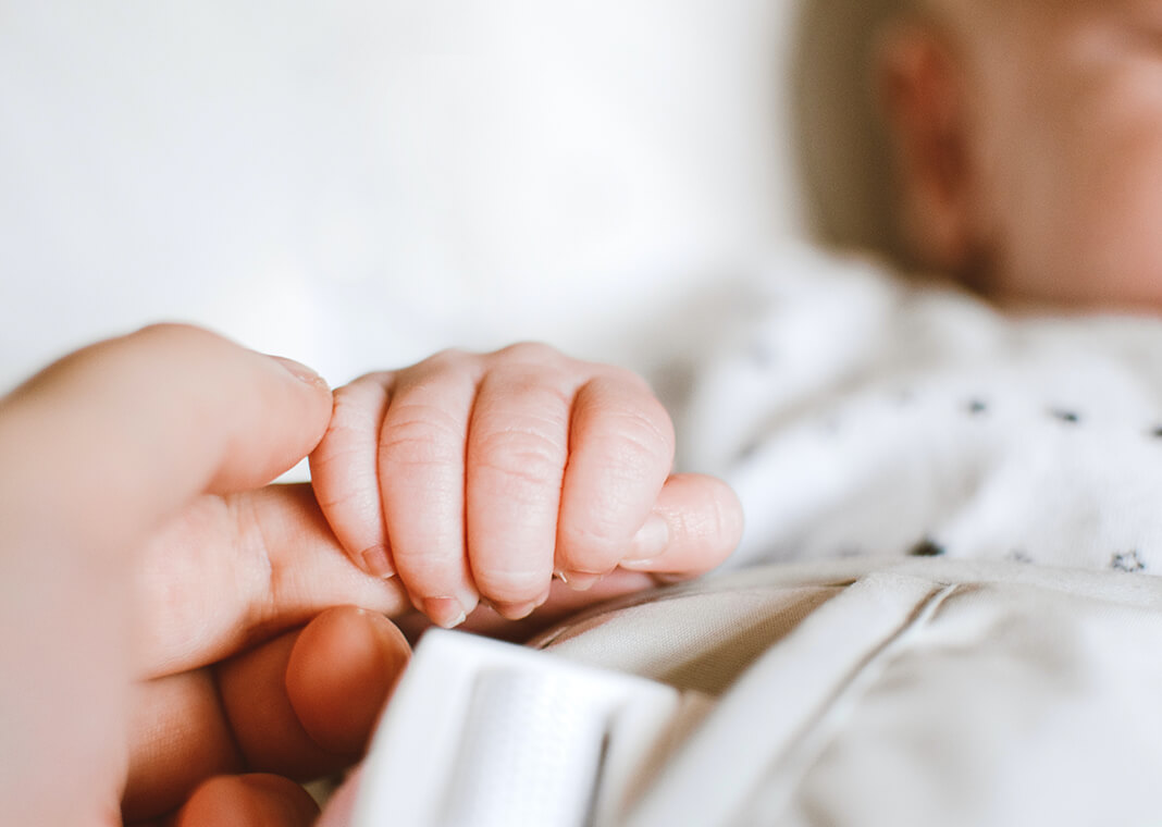mother holding baby's hand - photo by Lisa from Pexels