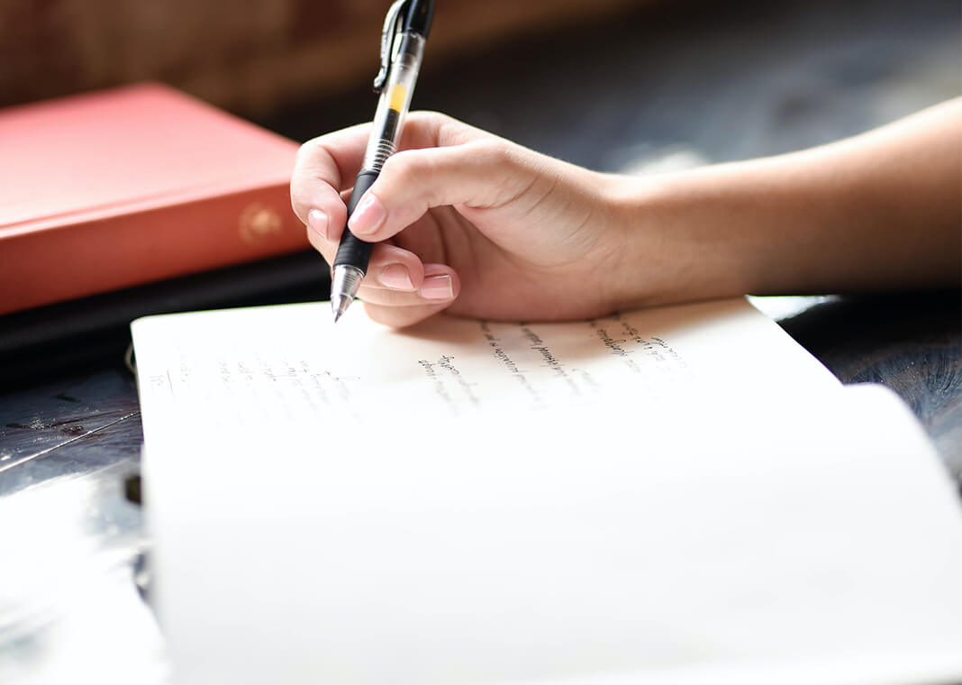 woman writing - photo by Hannah Olinger on Unsplash