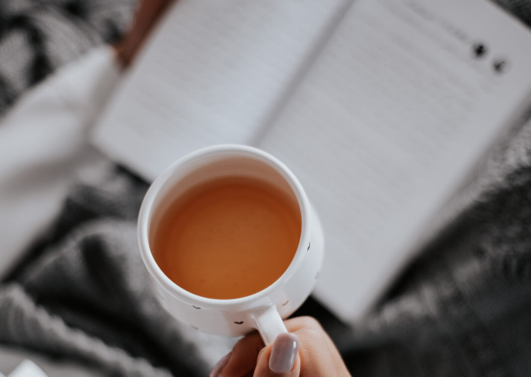 close-up of woman's teacup as she reads - photo by Farzad Mohamadi on Unsplash