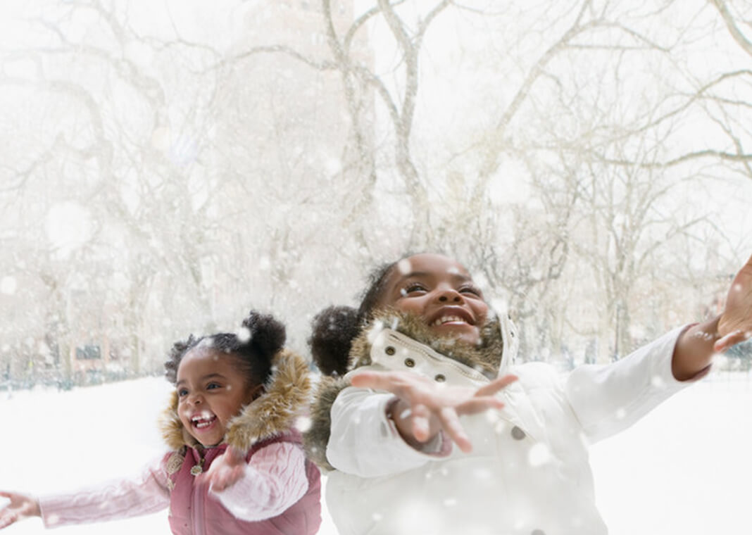 girls with arms open to catch snowflakes - photo by Jose Luis Pelaez Inc/Digital Vision/Getty Images