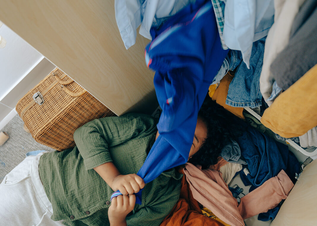 girl with messy stack of clothes - photo by Ketut Subiyanto from Pexels