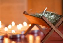 empty manger next to candles - udra/iStock/Getty Images