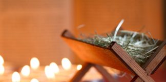 empty manger next to candles - udra/iStock/Getty Images