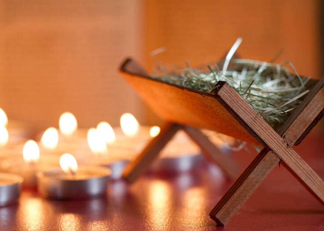 empty manger next to candles - udra/iStock/Getty Images