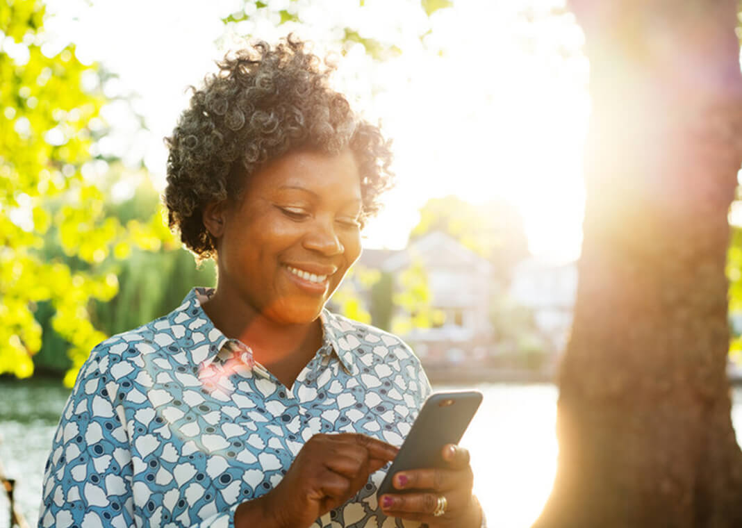 smiling woman with phone outside - Tim Robberts/Digital Vision/Getty Images