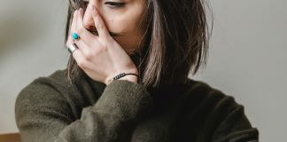 depressed woman sitting with hand over face - photo by Liza Summer via Pexels