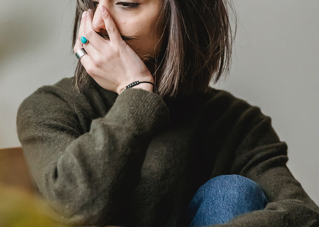 depressed woman sitting with hand over face - photo by Liza Summer via Pexels