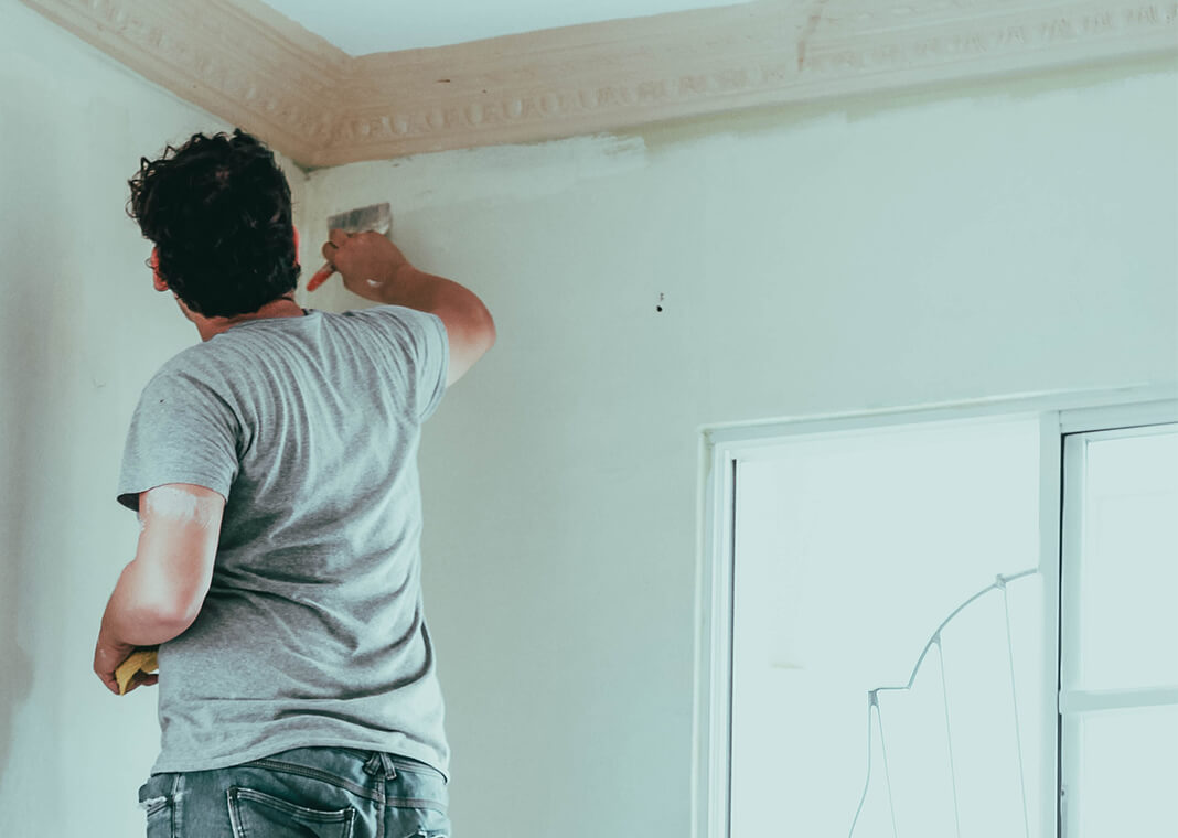 man painting wall - photo by Roselyn Tirado on Unsplash