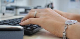 woman typing wearing medical alert bracelet - photo by MedicAlert UK on Unsplash