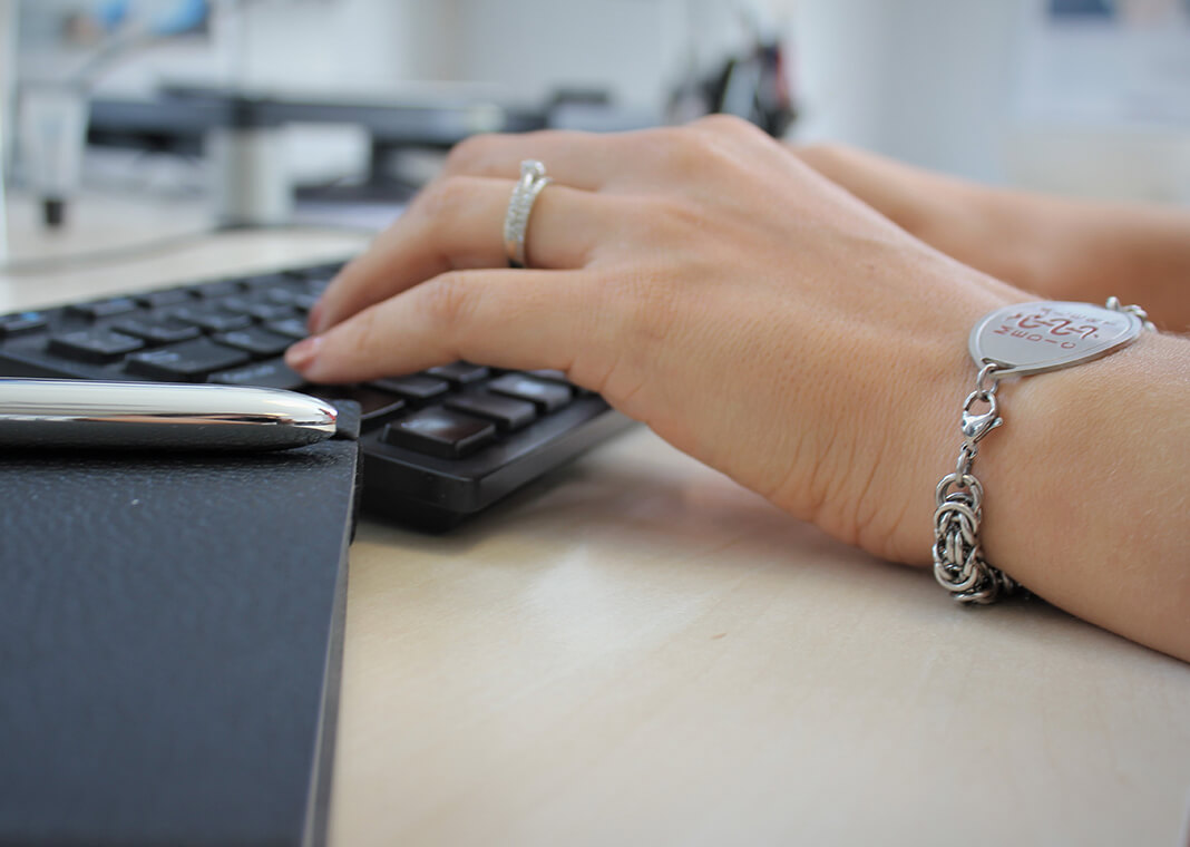 woman typing wearing medical alert bracelet - photo by MedicAlert UK on Unsplash