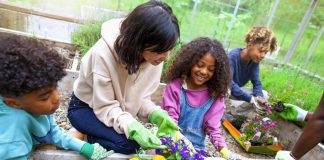 children gardening with help of adult woman - © Shannon Fagan - FangXiaNuo/E+/Getty Images