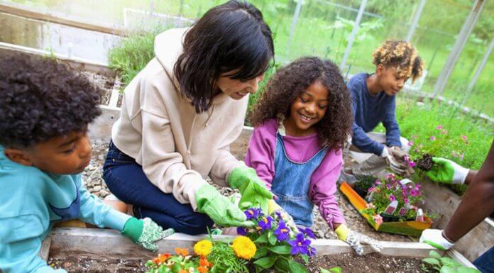 children gardening with help of adult woman - © Shannon Fagan - FangXiaNuo/E+/Getty Images