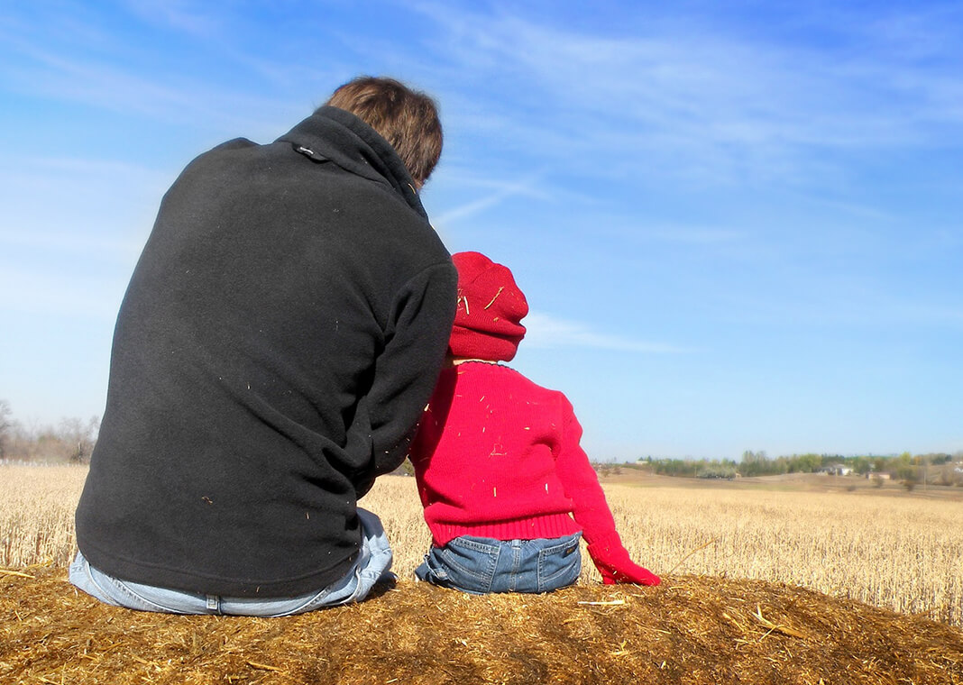 father and young child sitting outside, snuggled together - image by faithfinder06 from Pixabay