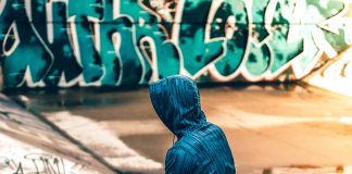 person sitting near graffiti wall - photo by Warren on Unsplash