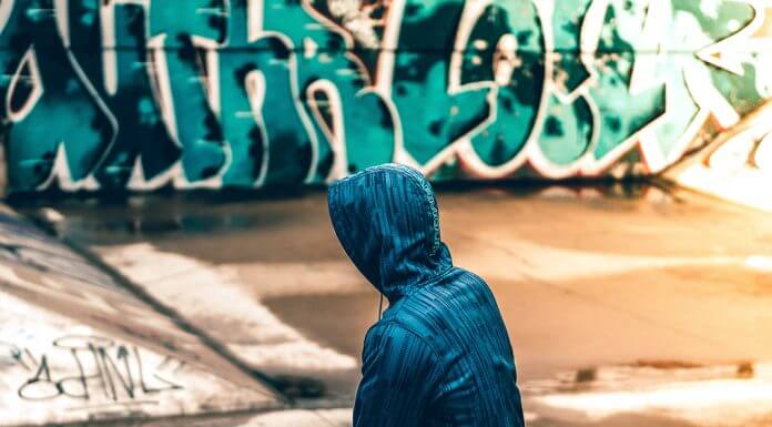 person sitting near graffiti wall - photo by Warren on Unsplash