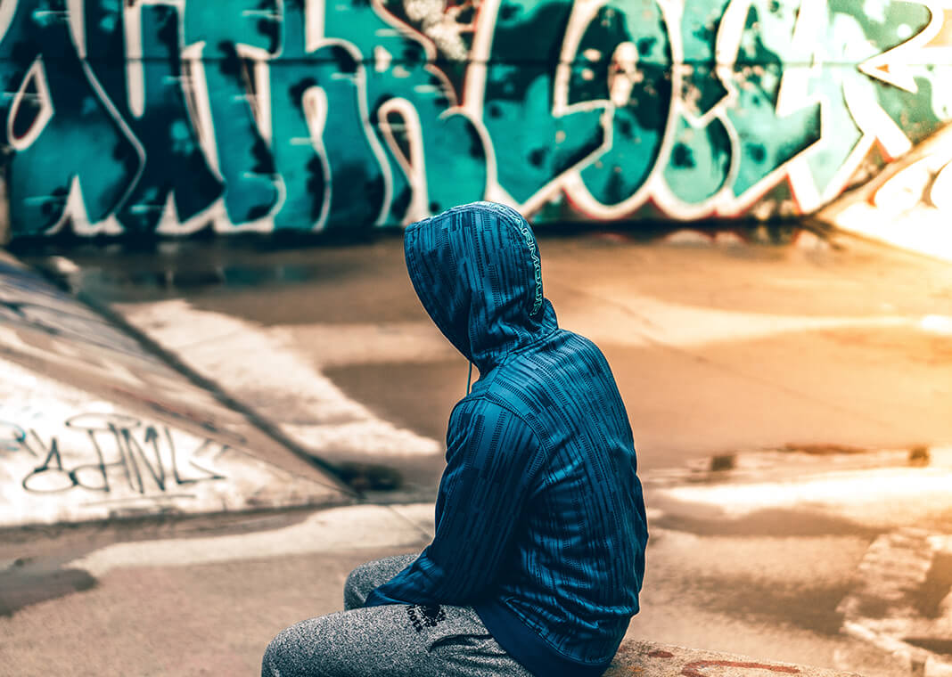 person sitting near graffiti wall - photo by Warren on Unsplash