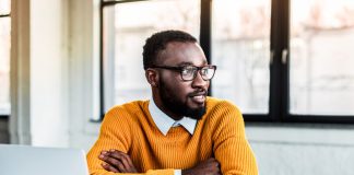 man sitting at computer with arms folded - LightFieldStudios/iStock/Getty Images