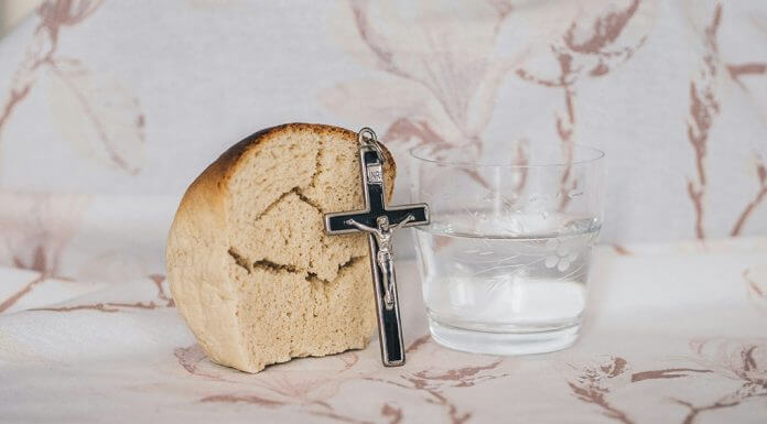 bread, water, and crucifix - photo by Kamil Szumotalski on Unsplash