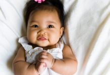 baby with pink bow in hair - azndc/iStock/Getty Images