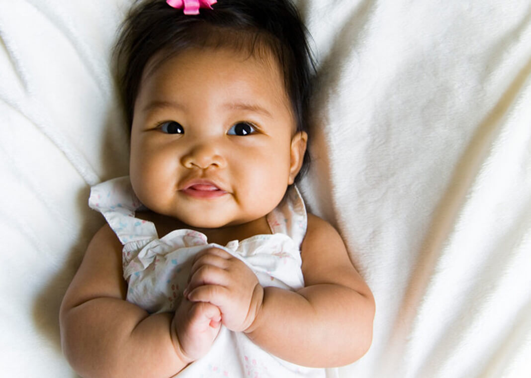 baby with pink bow in hair - azndc/iStock/Getty Images