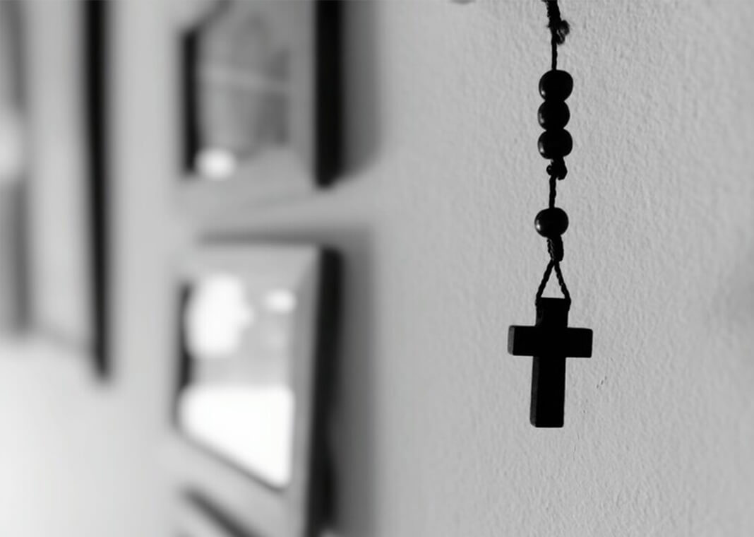 rosary hanging on wall with photo frames - Riccardo Livorni/EyeEm/Getty Images
