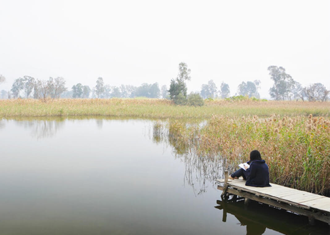 girl reflecting while sitting on pier waterside - leungchopan/Shutterstock.com