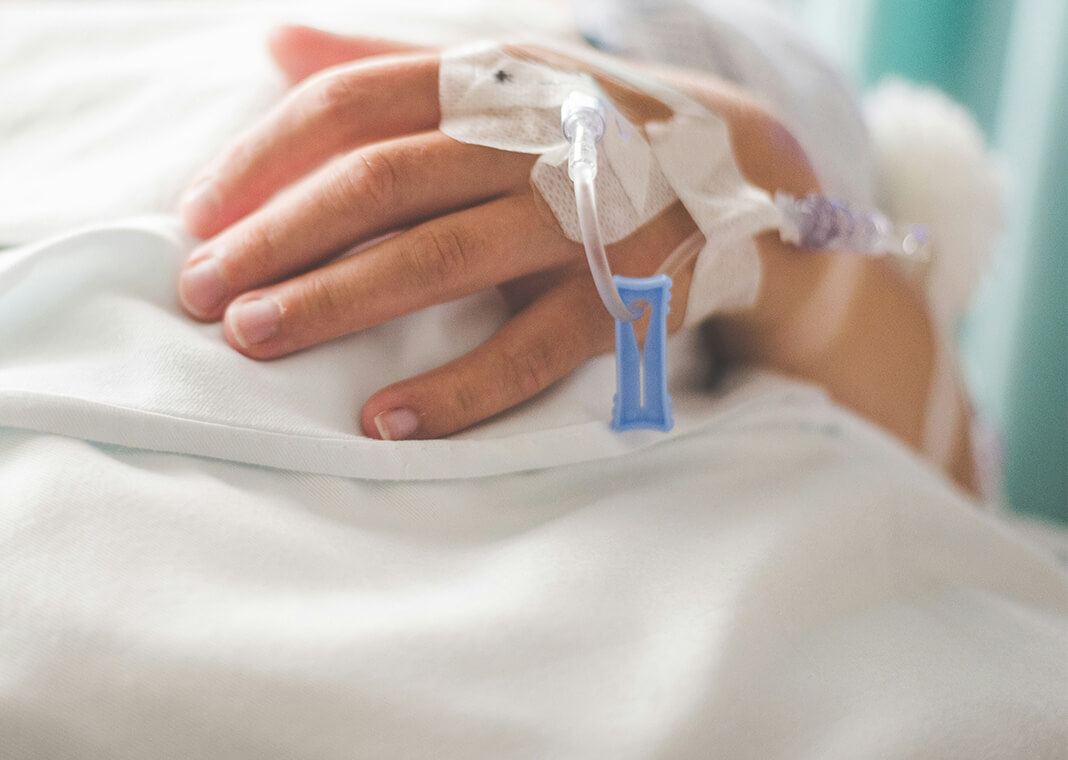 woman's hand with an IV in hospital - photo by Stephen Andrews on Unsplash