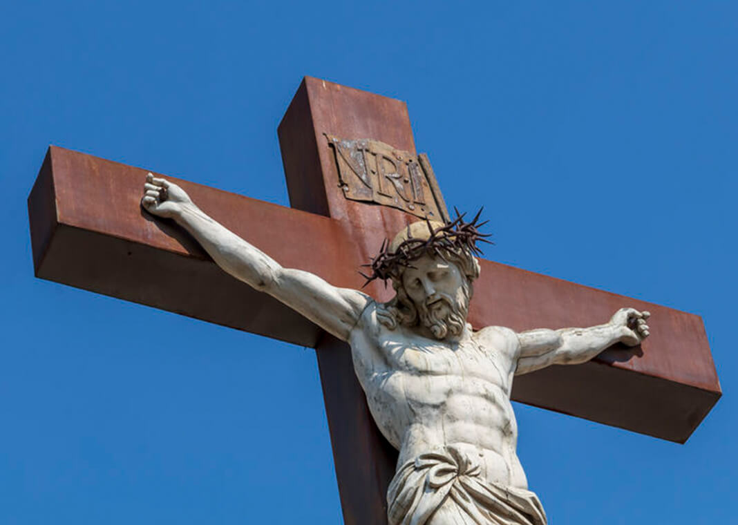 outdoor crucifix against a blue sky - Jekaterina Sahmanova/iStock/Getty Images