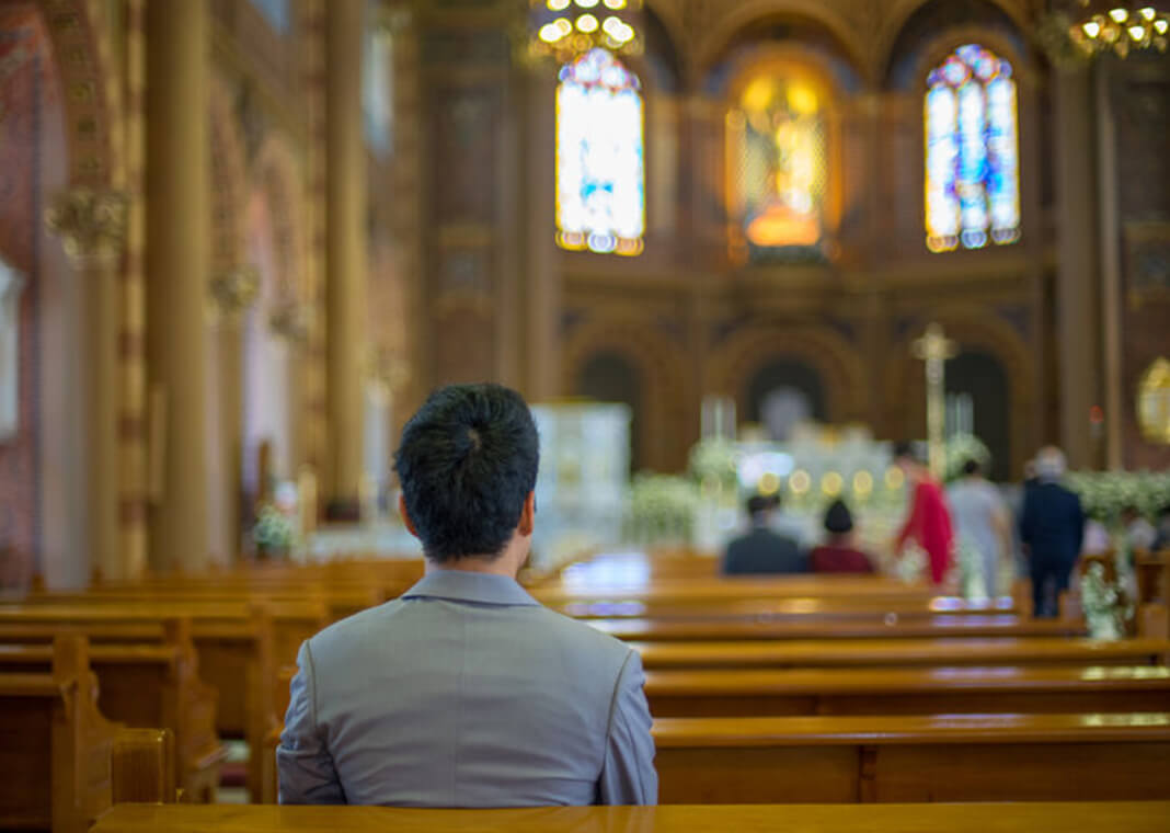 man sitting in church - Thoranin Nokyoo/Shutterstock.com