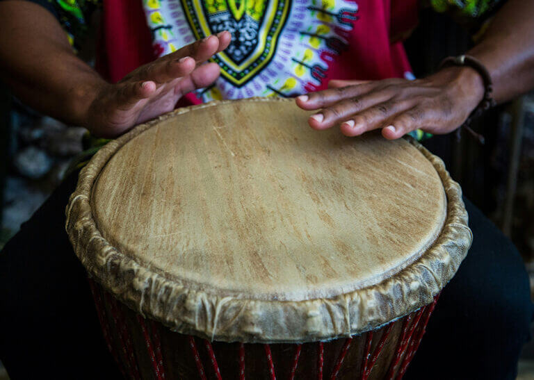 man playing djembe drum - photo by Luz Mendoza on Unsplash