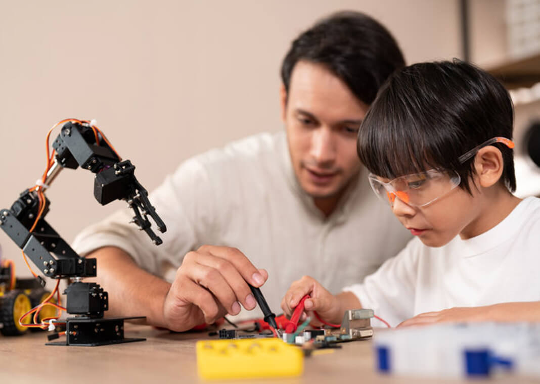 teacher helps student with circuits for robot - wera Rodsawang/Moment/Getty Images