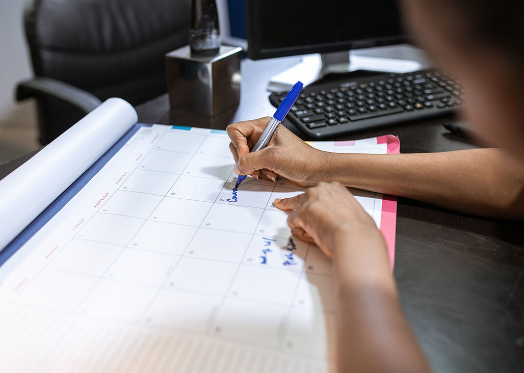 woman writing on desk calendar - photo by RDNE Stock project on Pexels.com