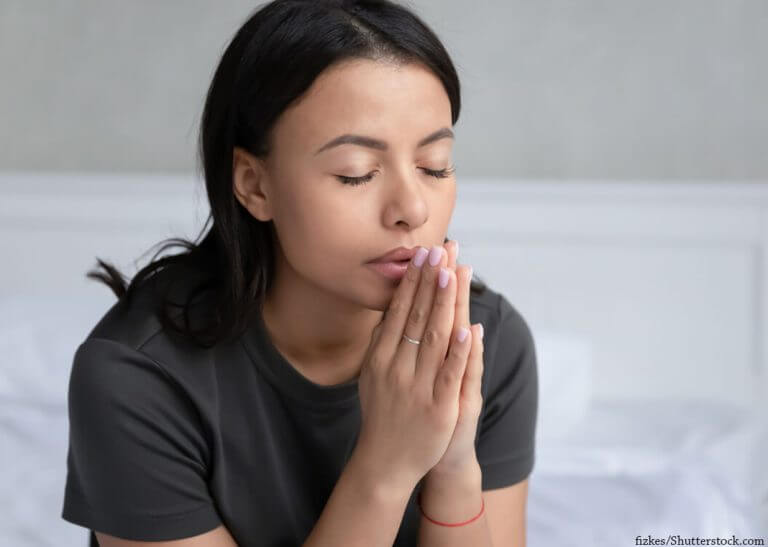 woman with hands folded in expectant prayer - fizkes/Shutterstock.com